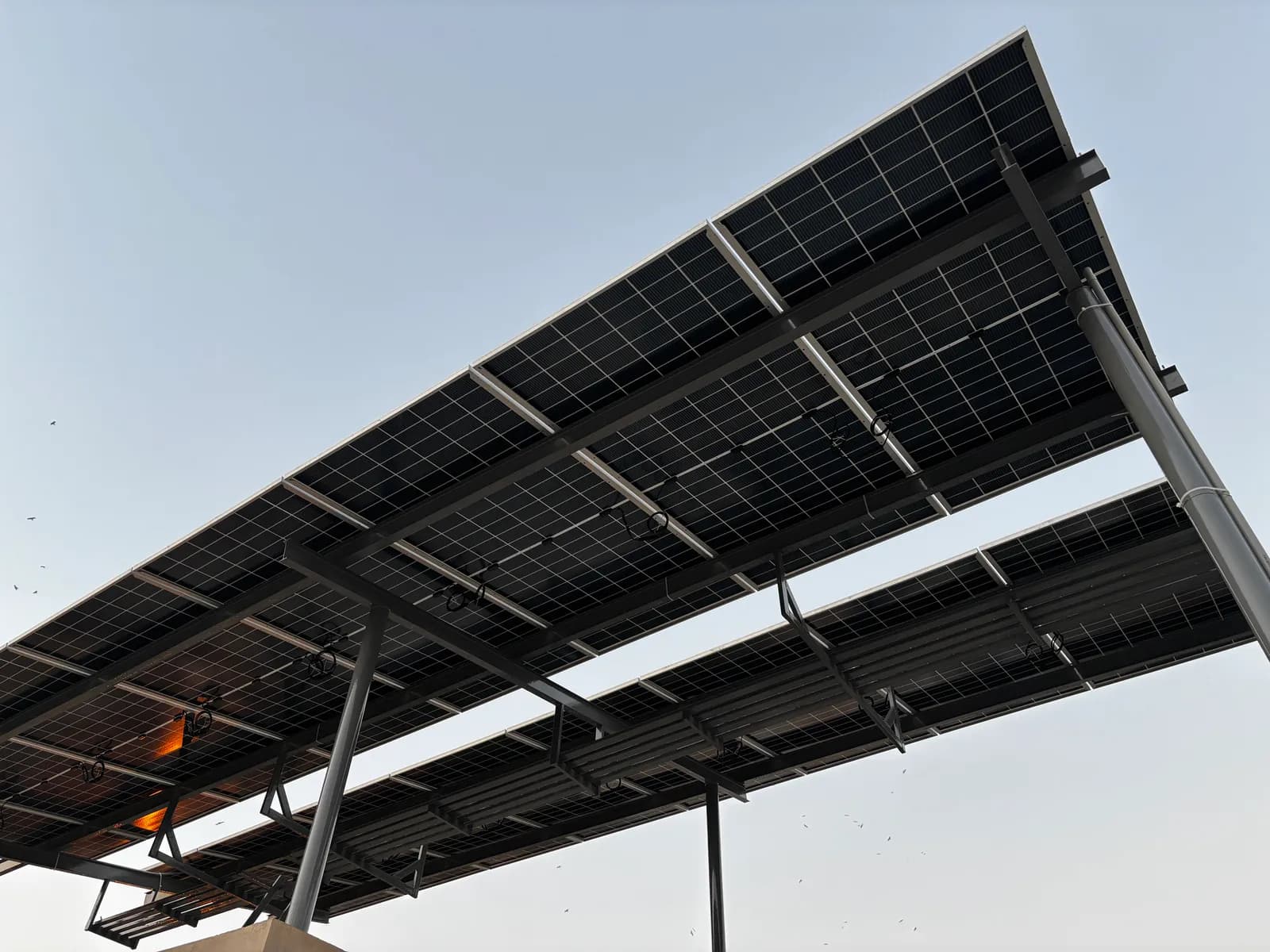 Elevated steel-frame solar array installed by APC Solar above a Karachi rooftop
