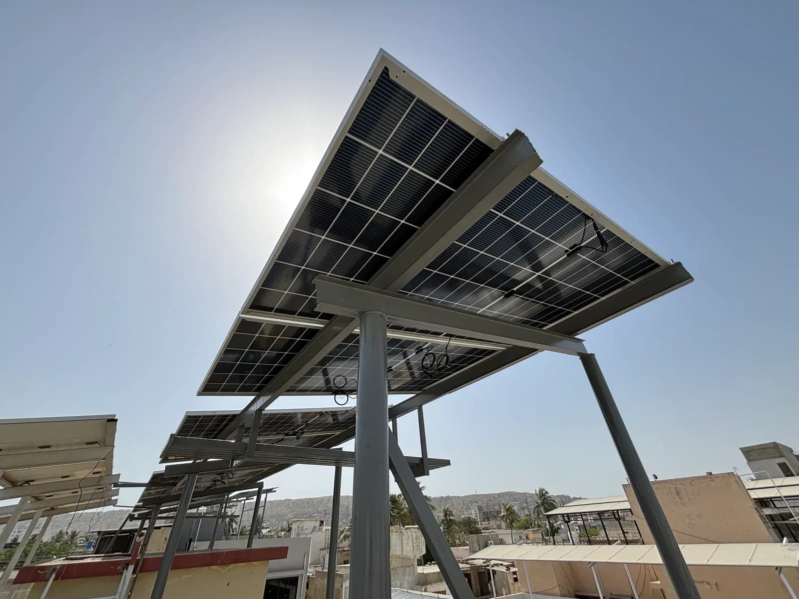 Elevated canopy-style solar array by APC Solar shading a Karachi rooftop