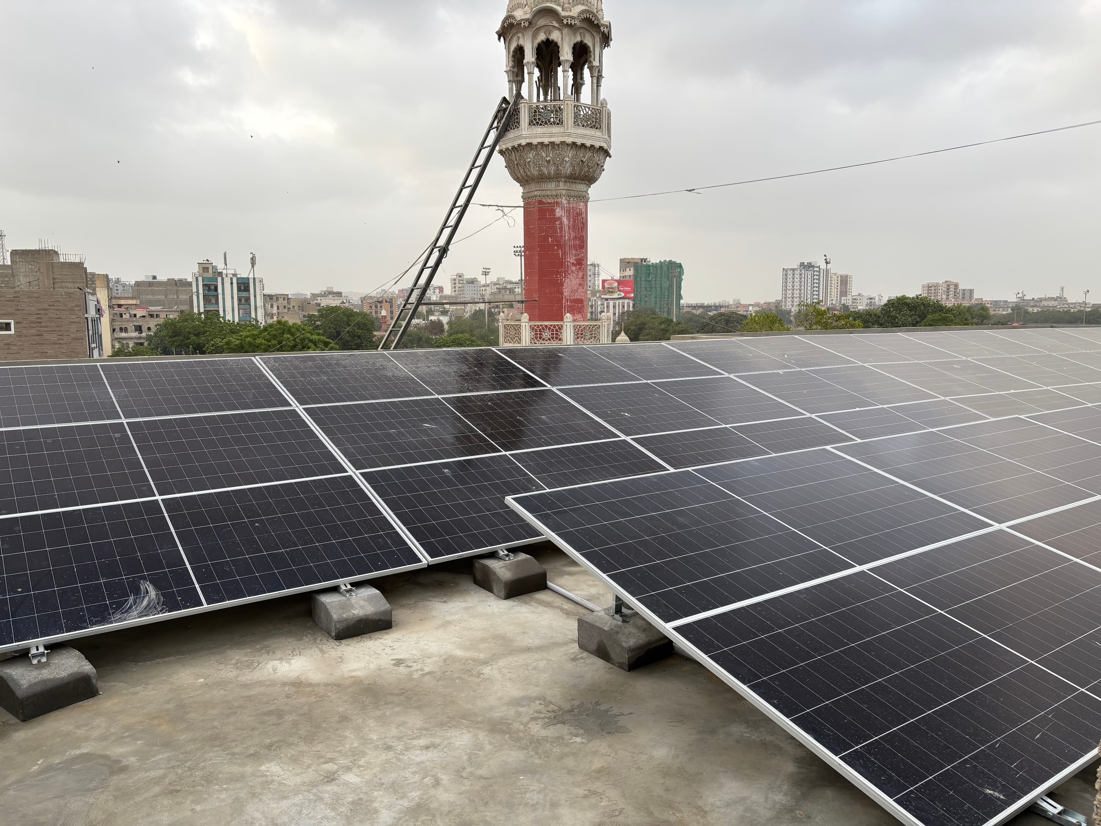 An APC Solar rooftop installation in Karachi, panels under a clear sky