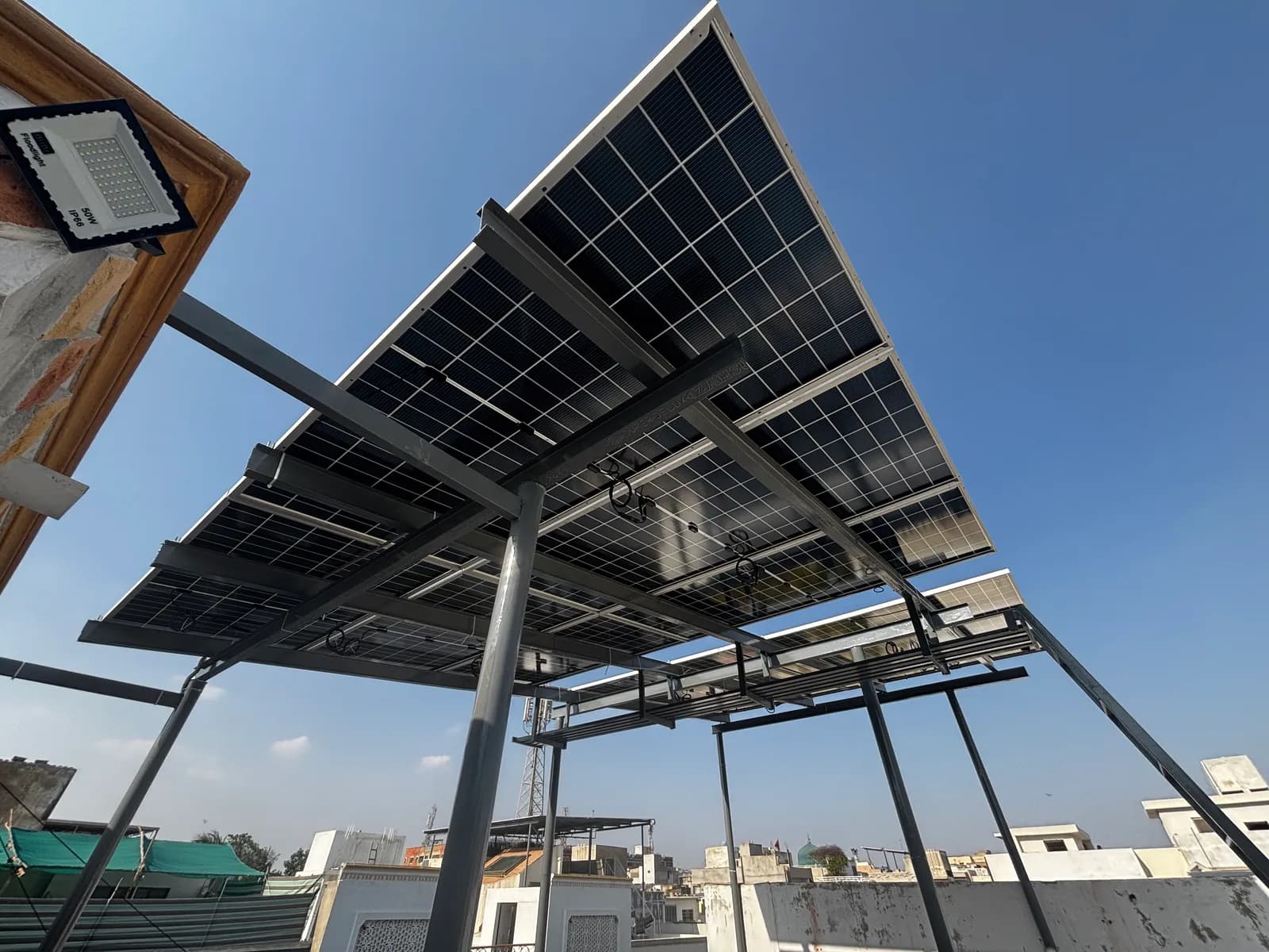 Elevated rooftop solar array on a galvanised steel structure by APC Solar in Karachi